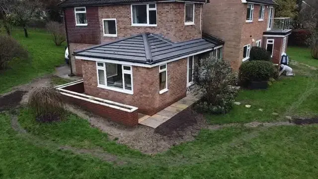 Brick house extension with pitched roof by Godman Construction, adding modern space to the property.