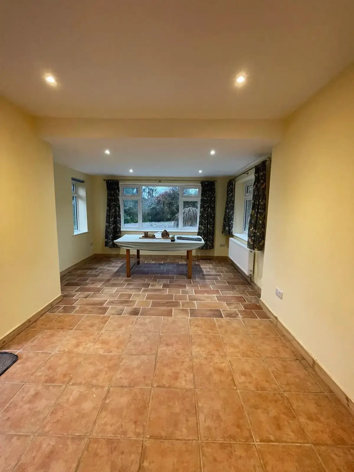 Bright family room with terracotta tiles and ceiling spotlights