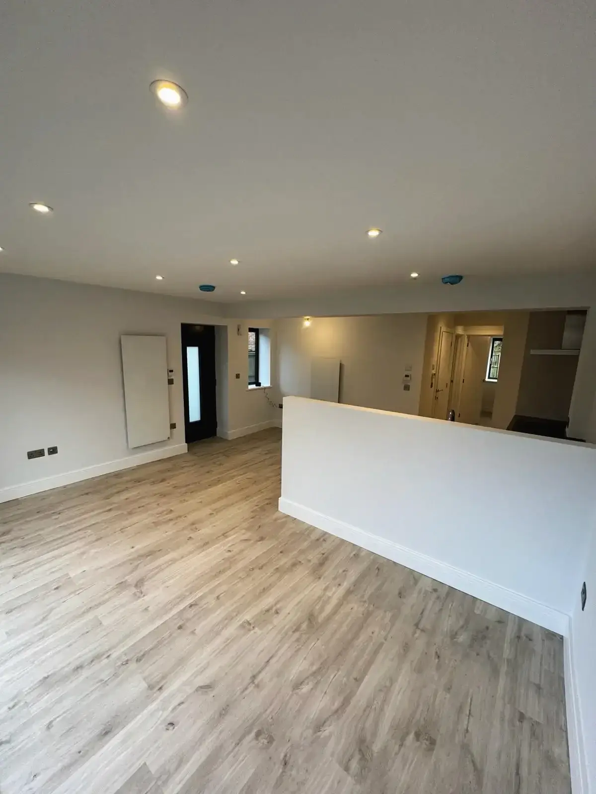 Bright open space with recessed lighting, light wood flooring, and white finish