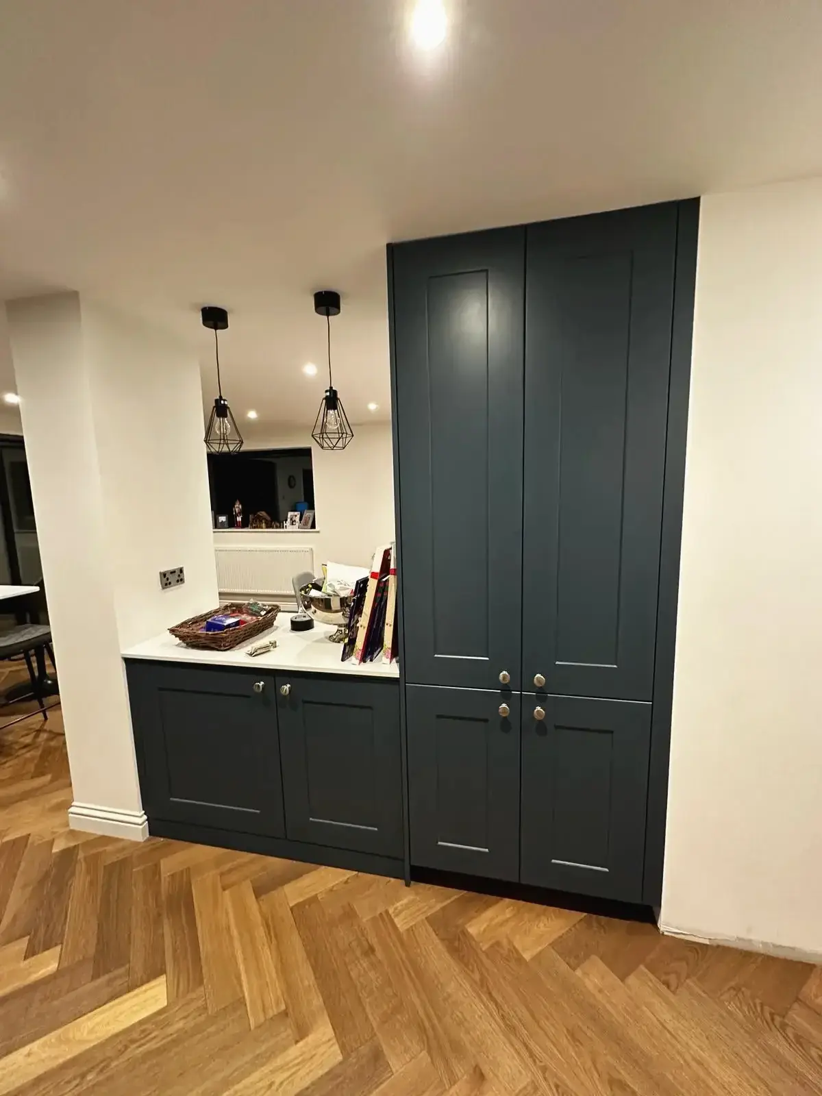 Built-in storage cabinets with marble countertop and wood flooring