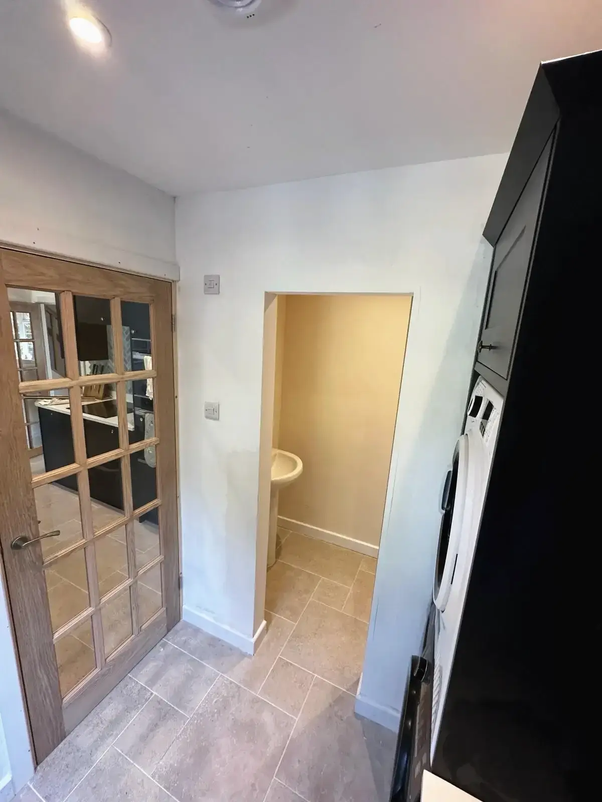 Compact utility and bathroom design with tiled floors