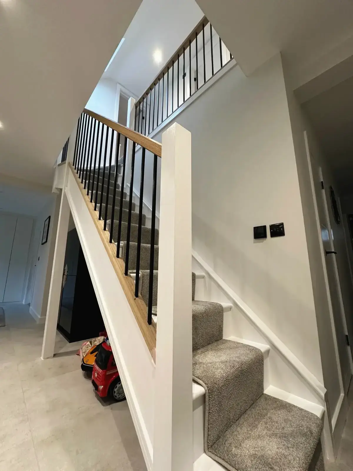 Contemporary hallway and stairs design featuring black balustrades and bright interior
