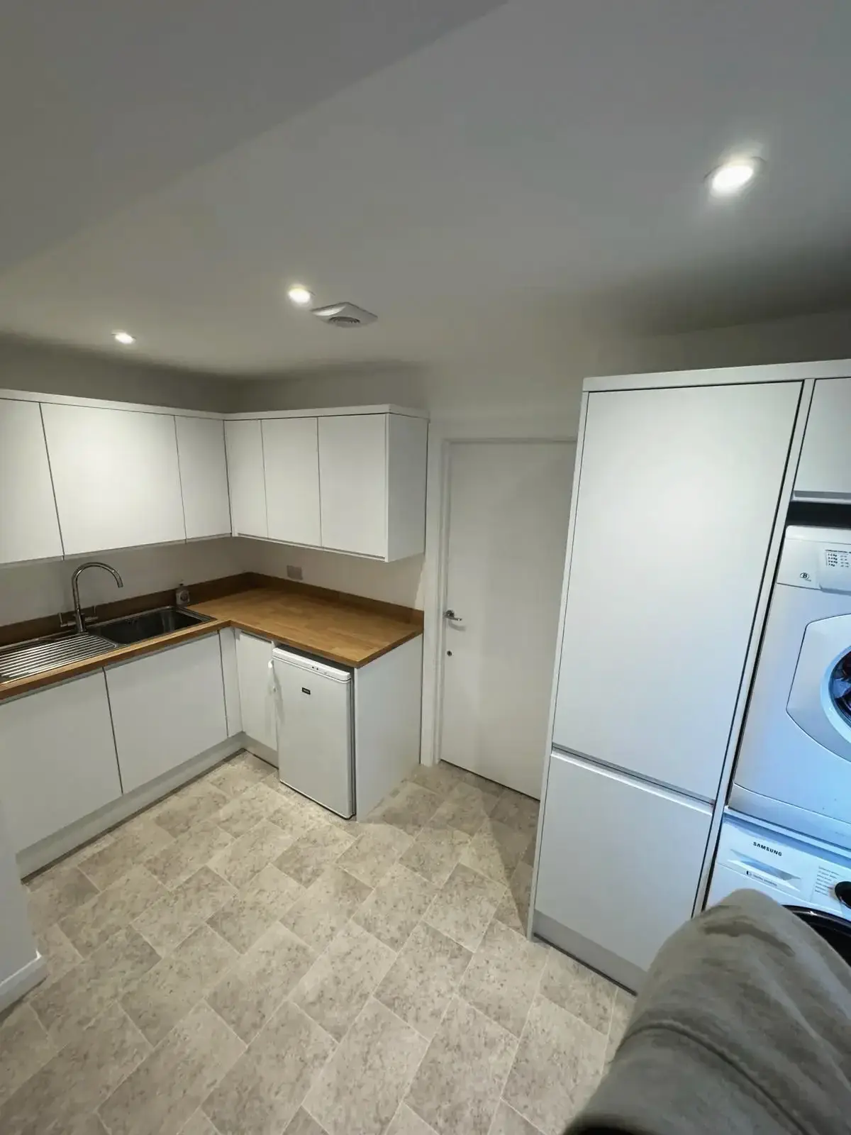 Contemporary kitchen makeover with bright white cupboards and natural wood tops