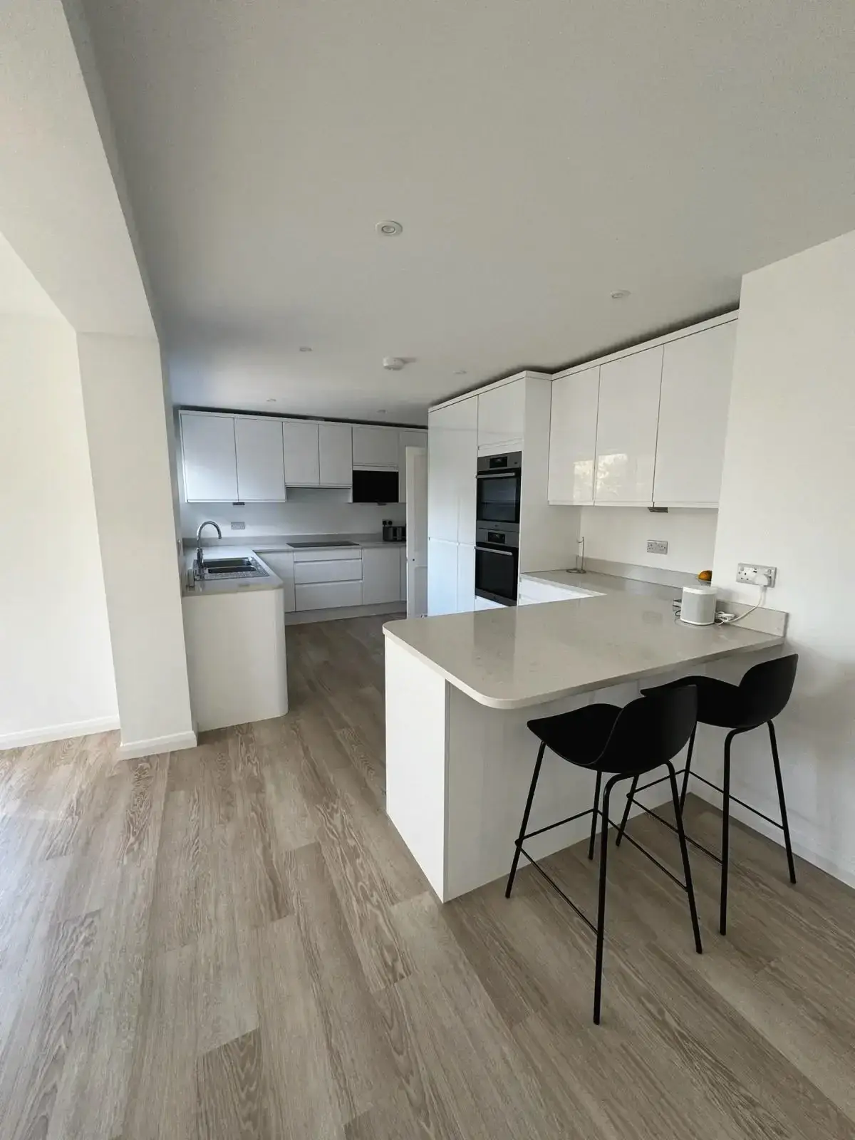 Contemporary kitchen renovation with sleek white cabinets and breakfast island