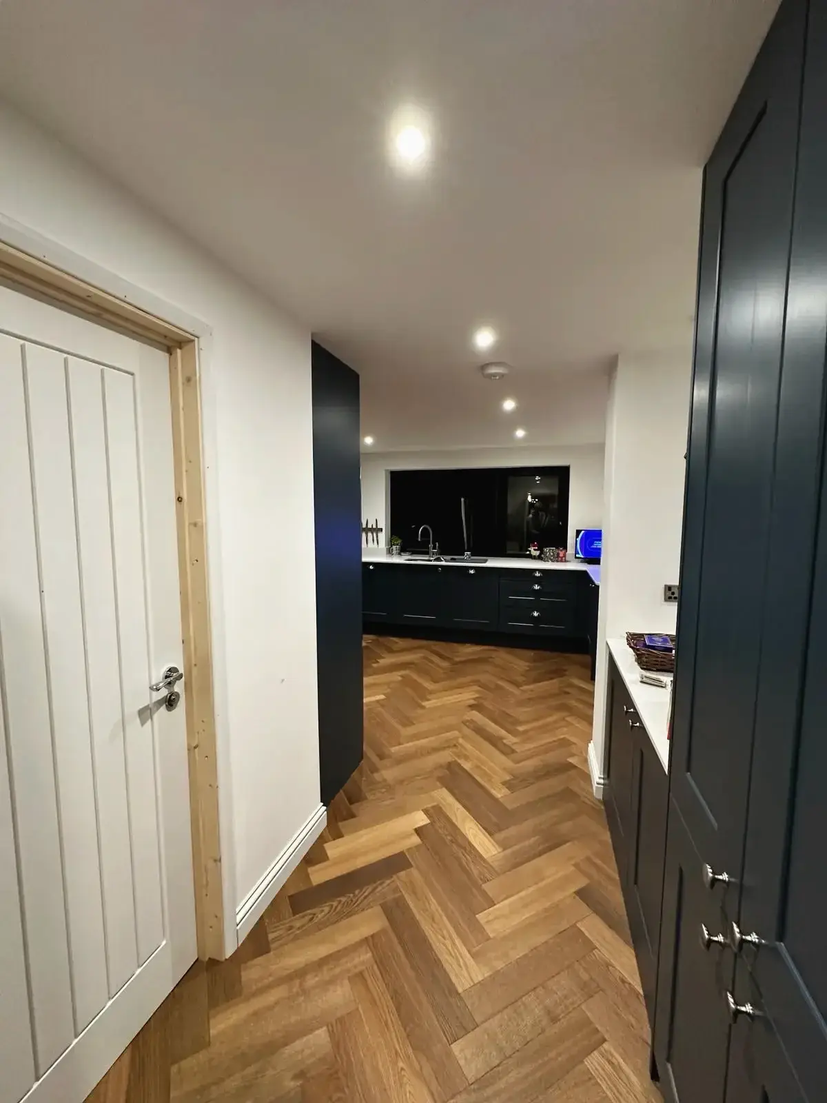 Contemporary shaker cabinetry with herringbone parquet floor
