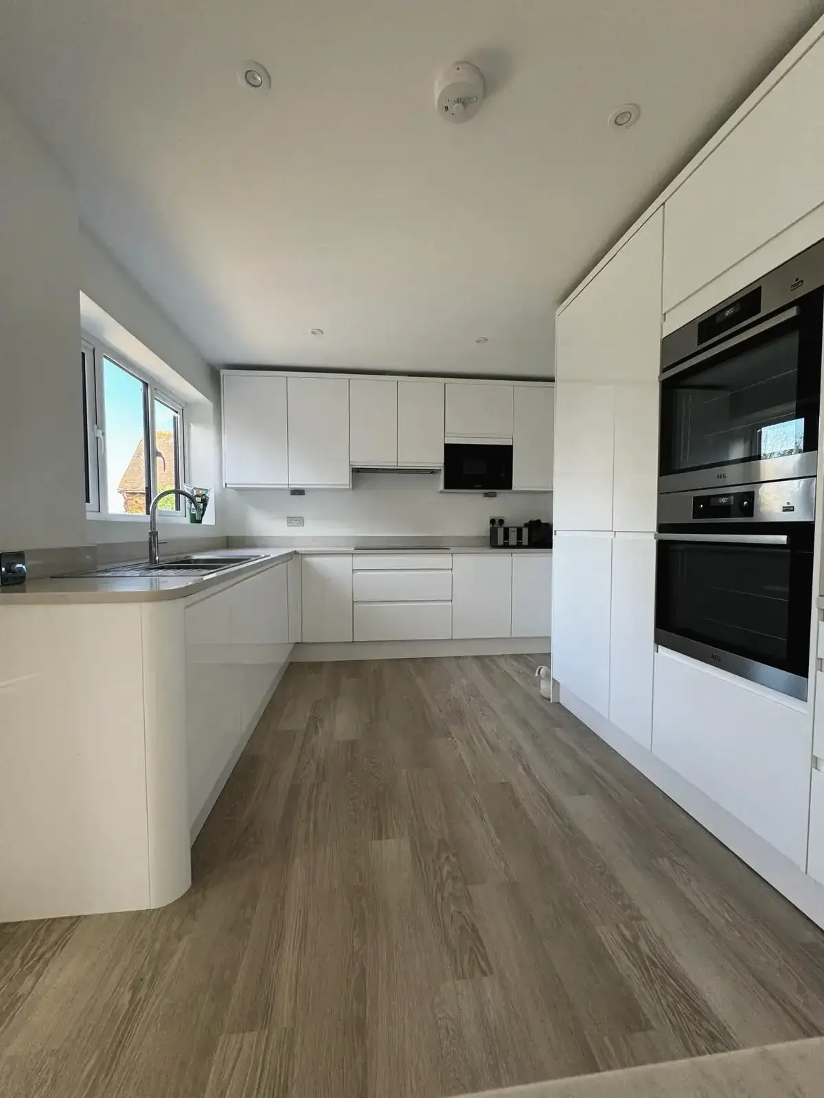 Contemporary white gloss kitchen with built-in oven and microwave