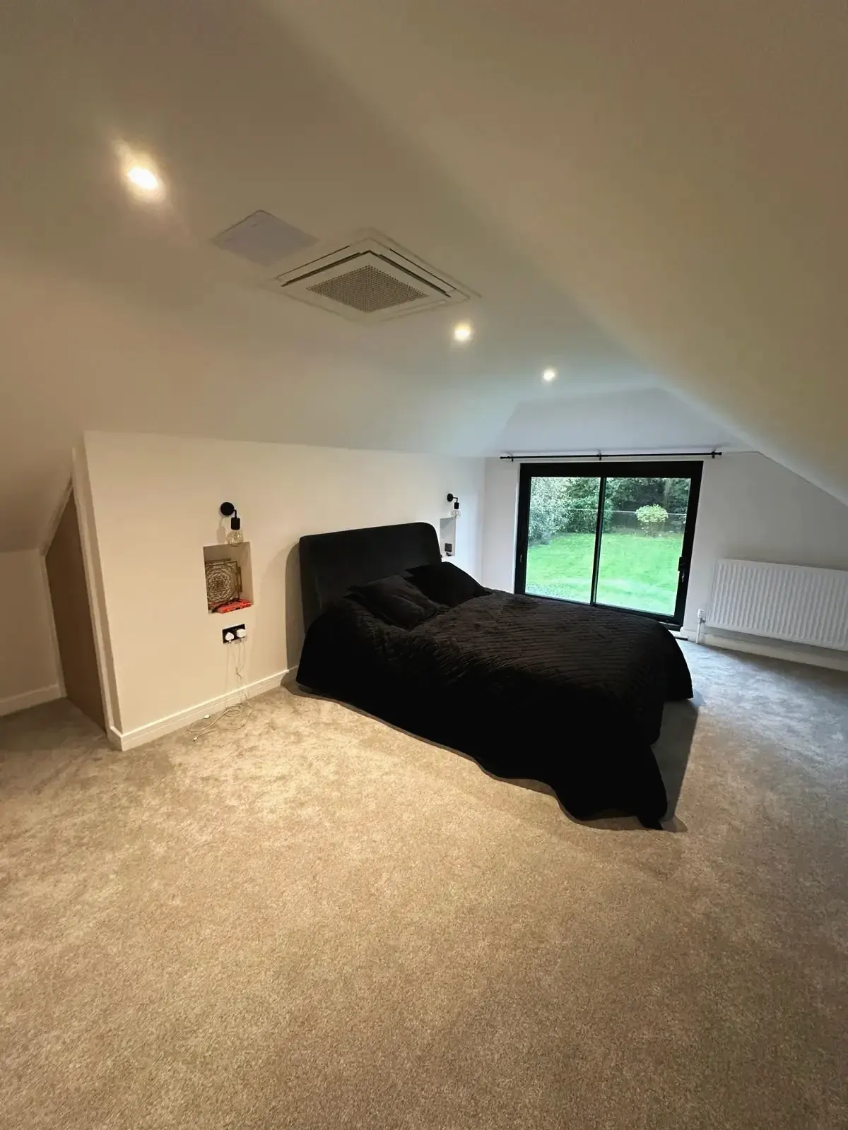 Converted loft bedroom with large window doors and contemporary design