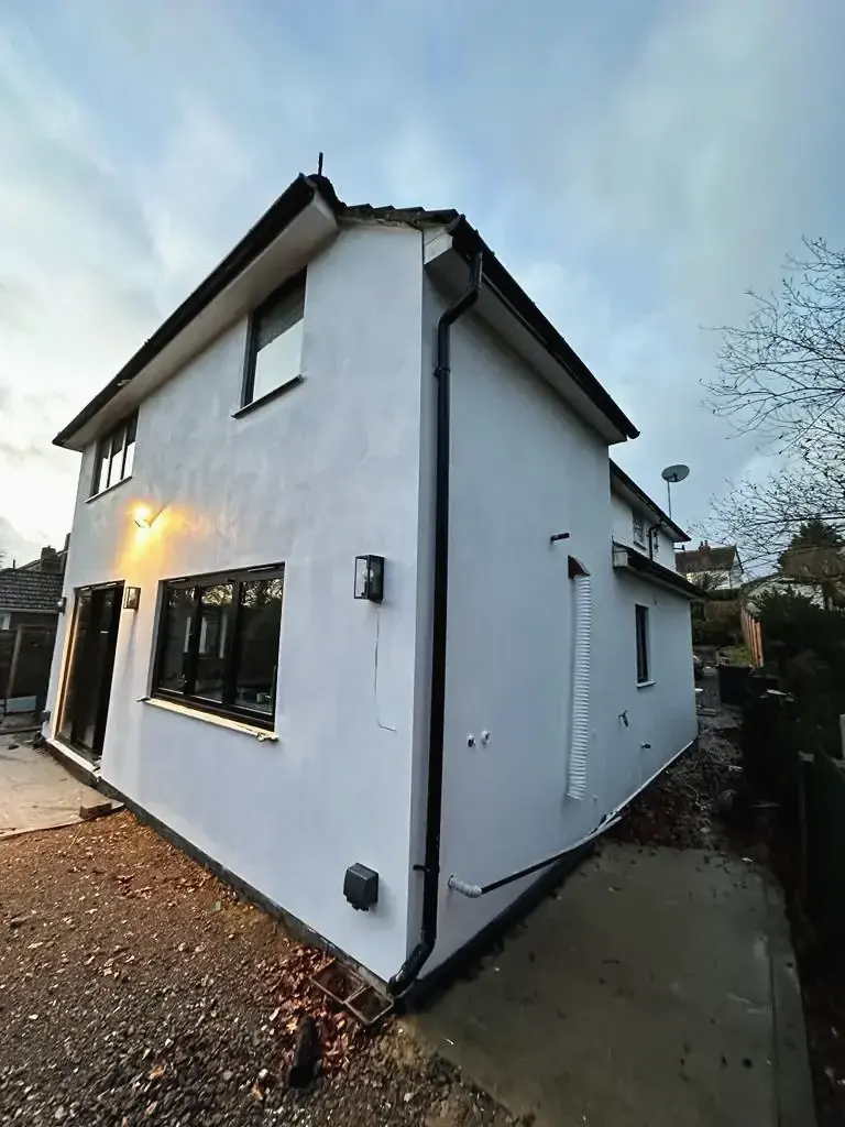 Exterior renovation featuring smooth white render finish