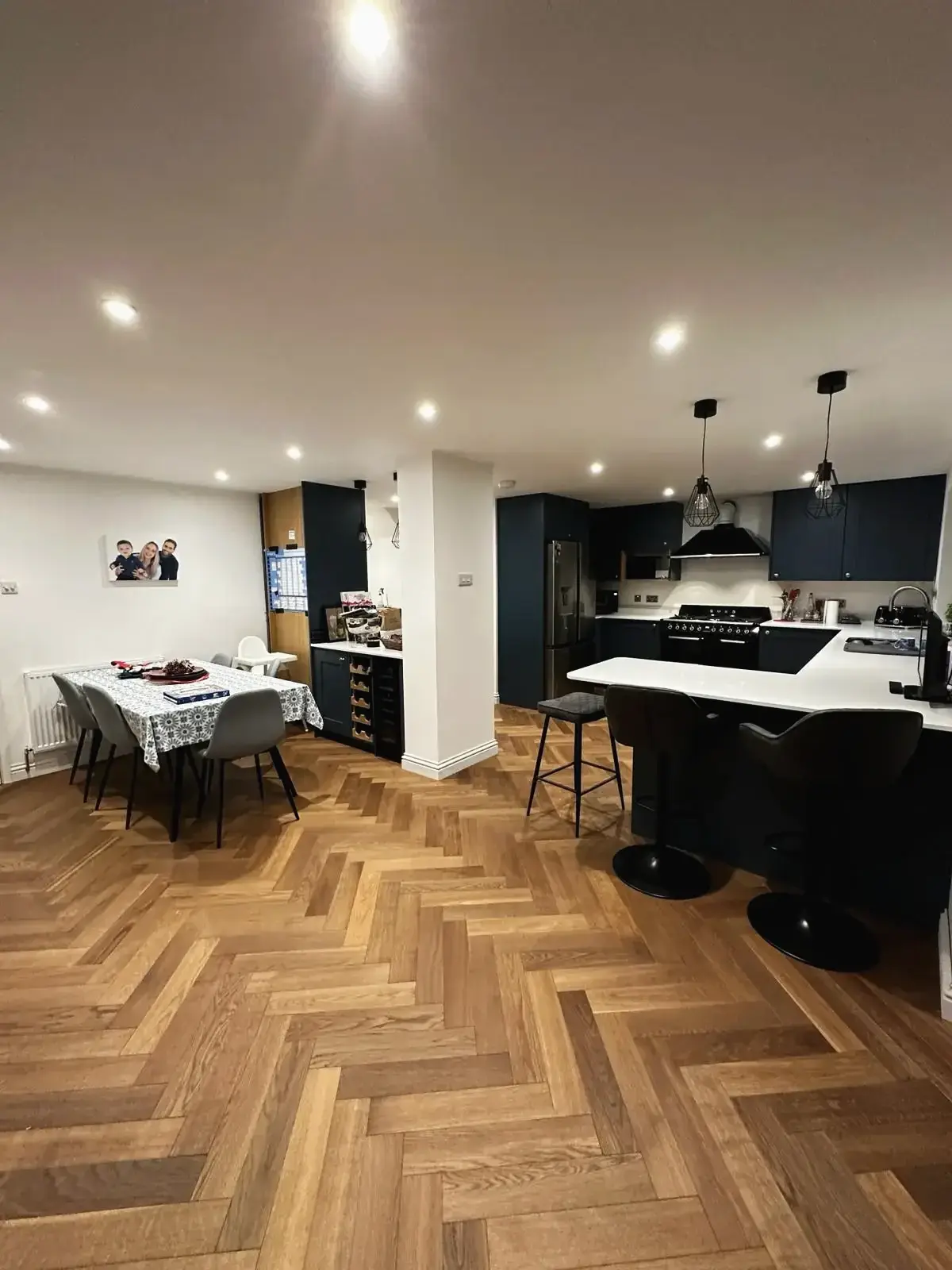 Family kitchen diner with modern navy units and oak parquet floor