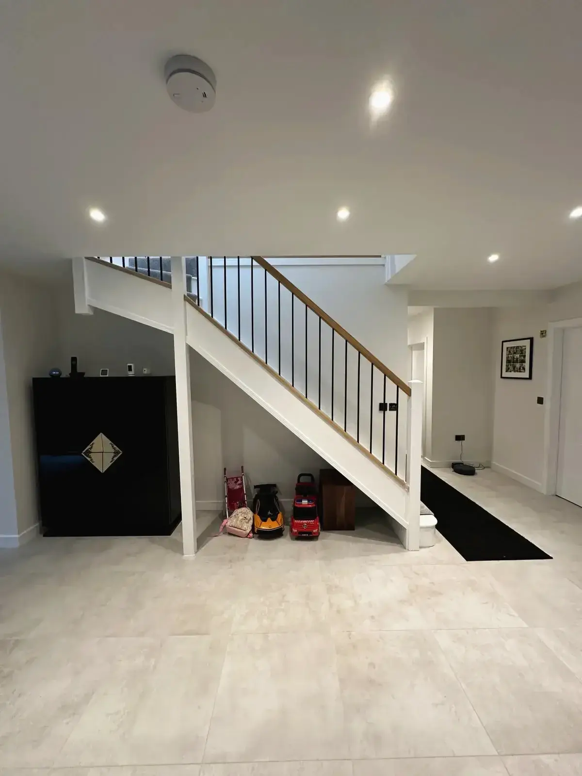 Front view of modern staircase with wooden handrail and tiled flooring