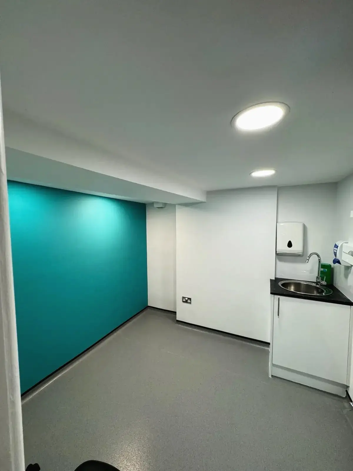 Interior teal corner of loft conversion designed as medical clinic