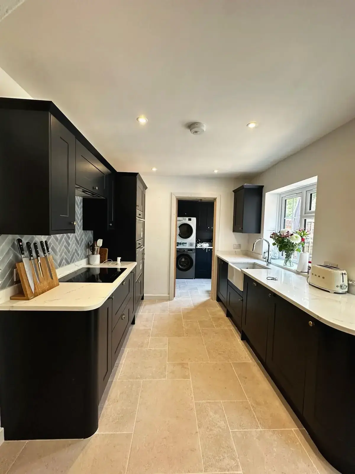 Kitchen design featuring marble countertop and black units