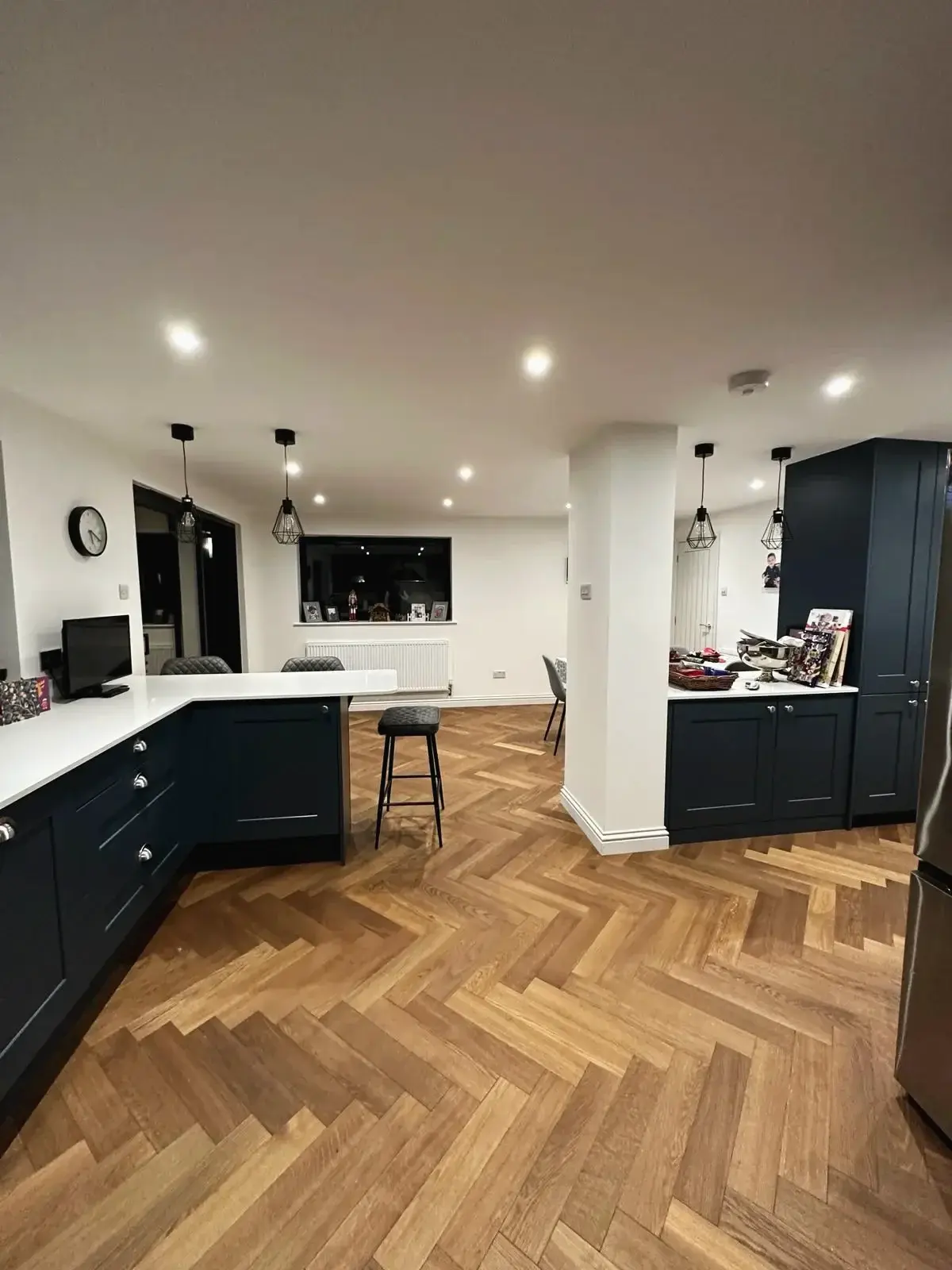 Kitchen diner extension with navy cabinetry and herringbone oak flooring