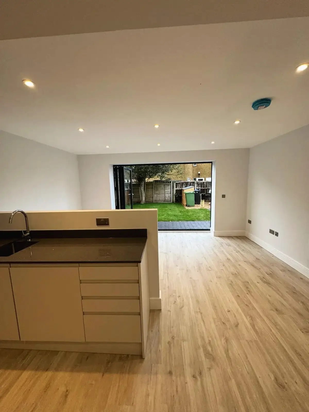 Kitchen island and open living space with garden access