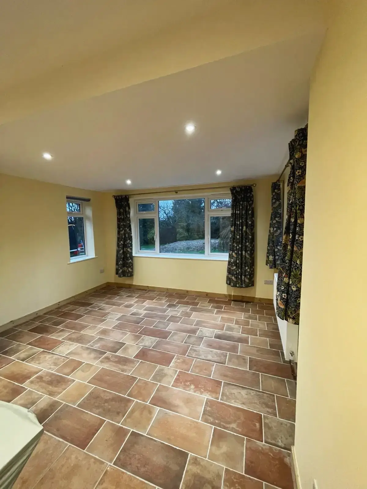 Living room renovation with terracotta tiled flooring and large windows