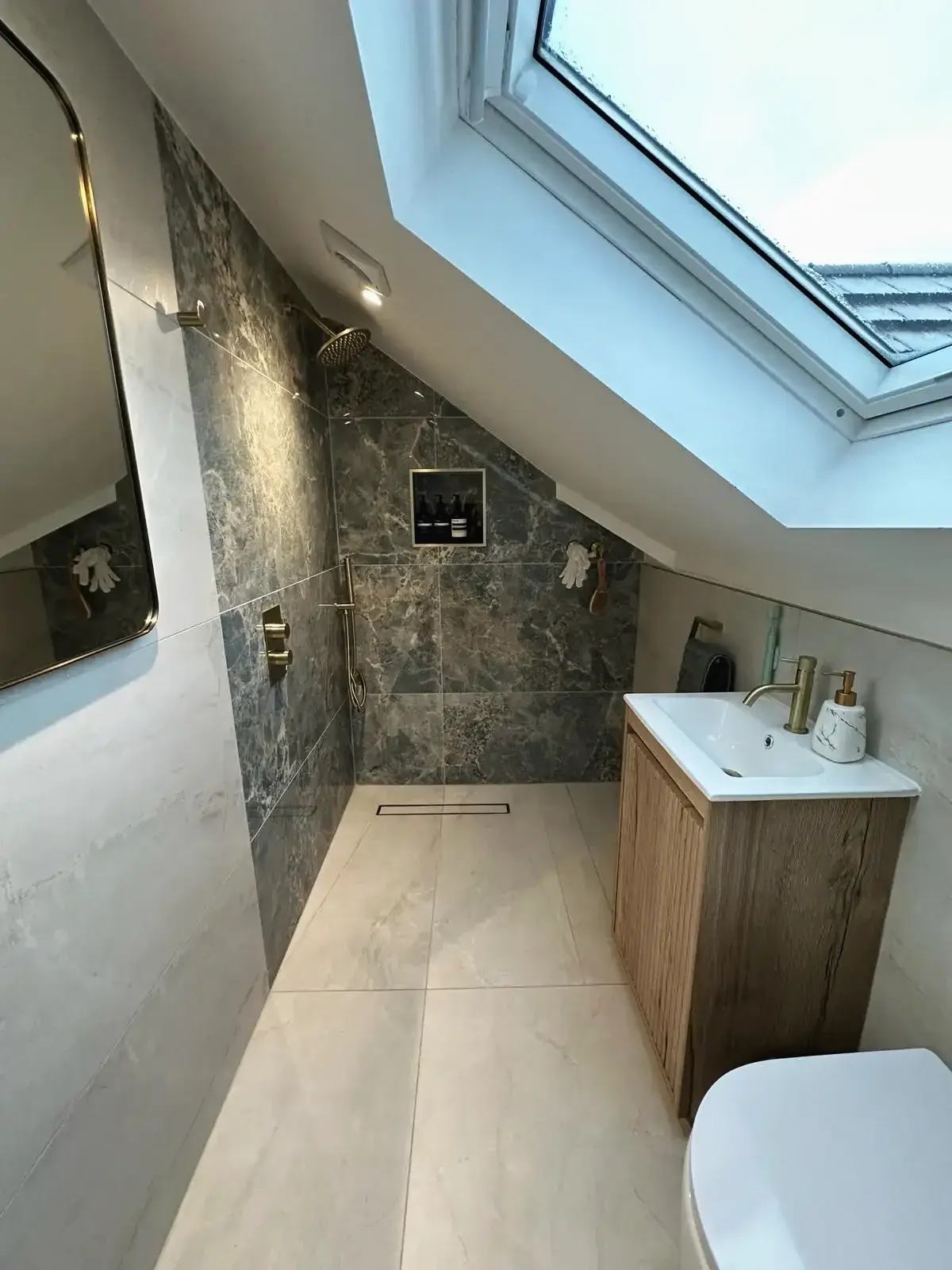 Loft conversion bathroom with skylight, walk-in shower, and modern finishes