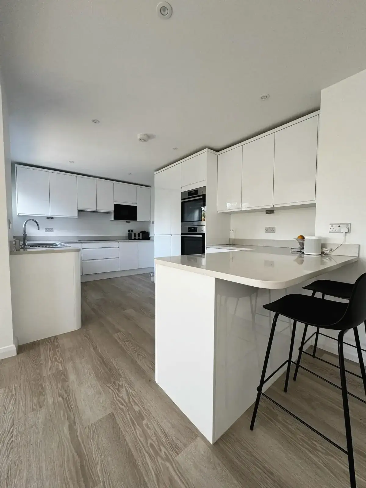 Minimalist kitchen interior with white cabinets and island seating