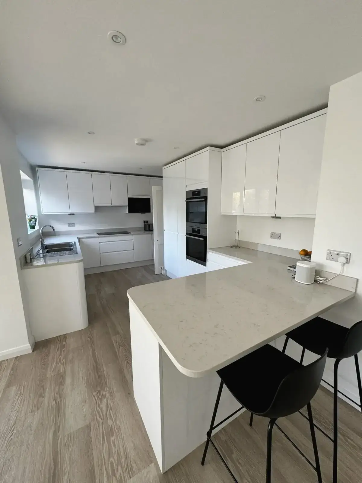 Minimalist kitchen with sleek white cabinetry and breakfast counter