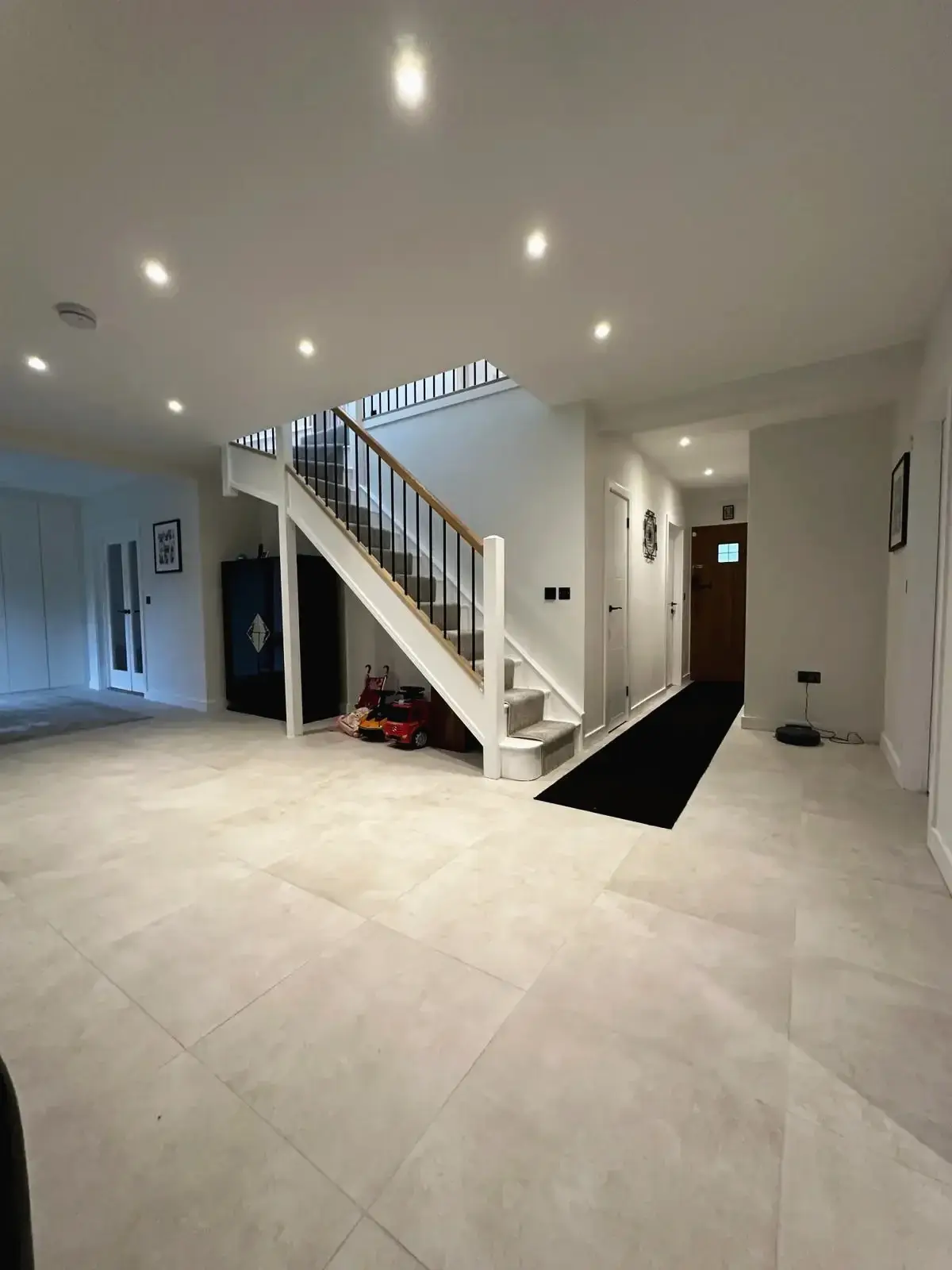 Modern hallway and sleek staircase in renovated open-plan home
