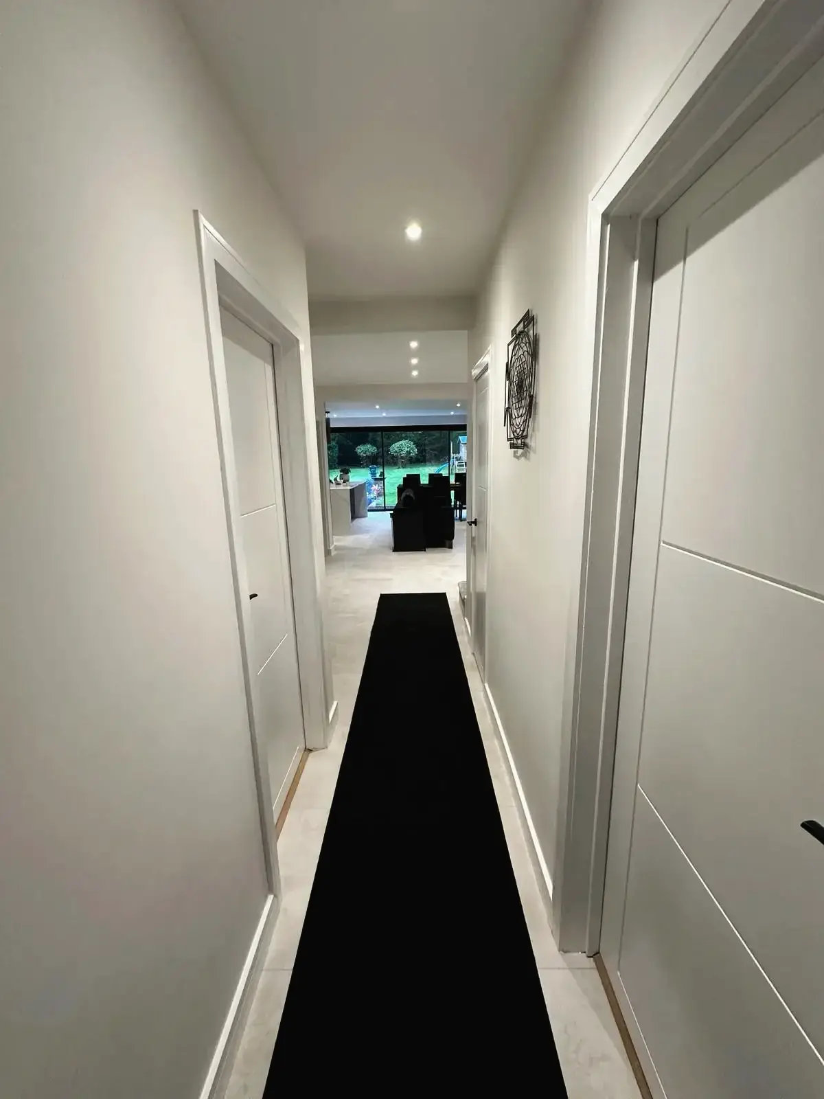 Modern hallway interior with white doors and black runner