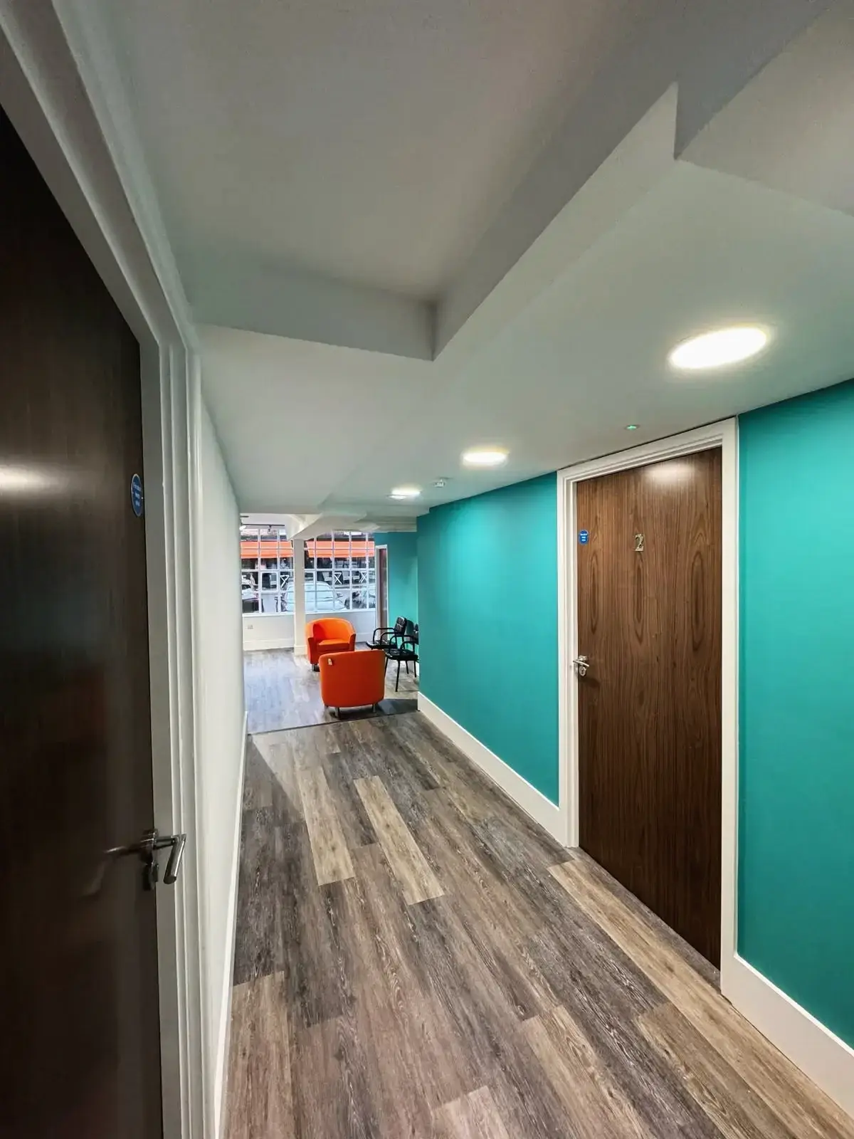 Modern interior hallway with wood doors and seating area