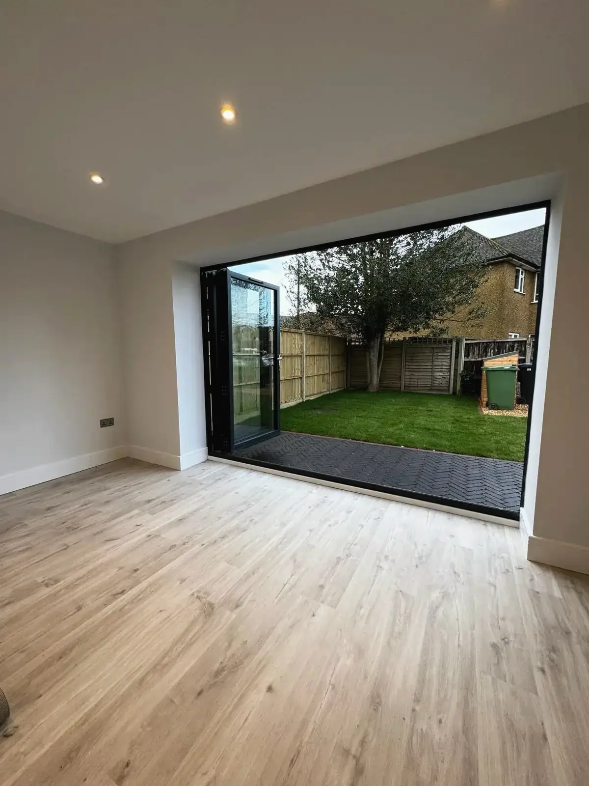 Modern interior with wooden flooring and outdoor garden access