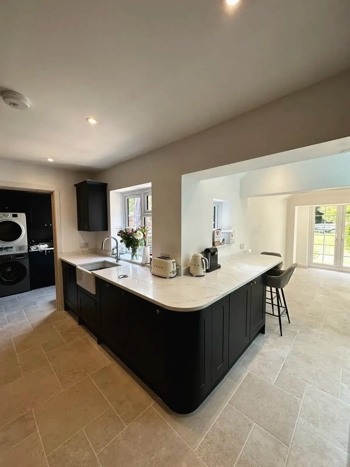 Modern kitchen island with marble worktop and black cabinets