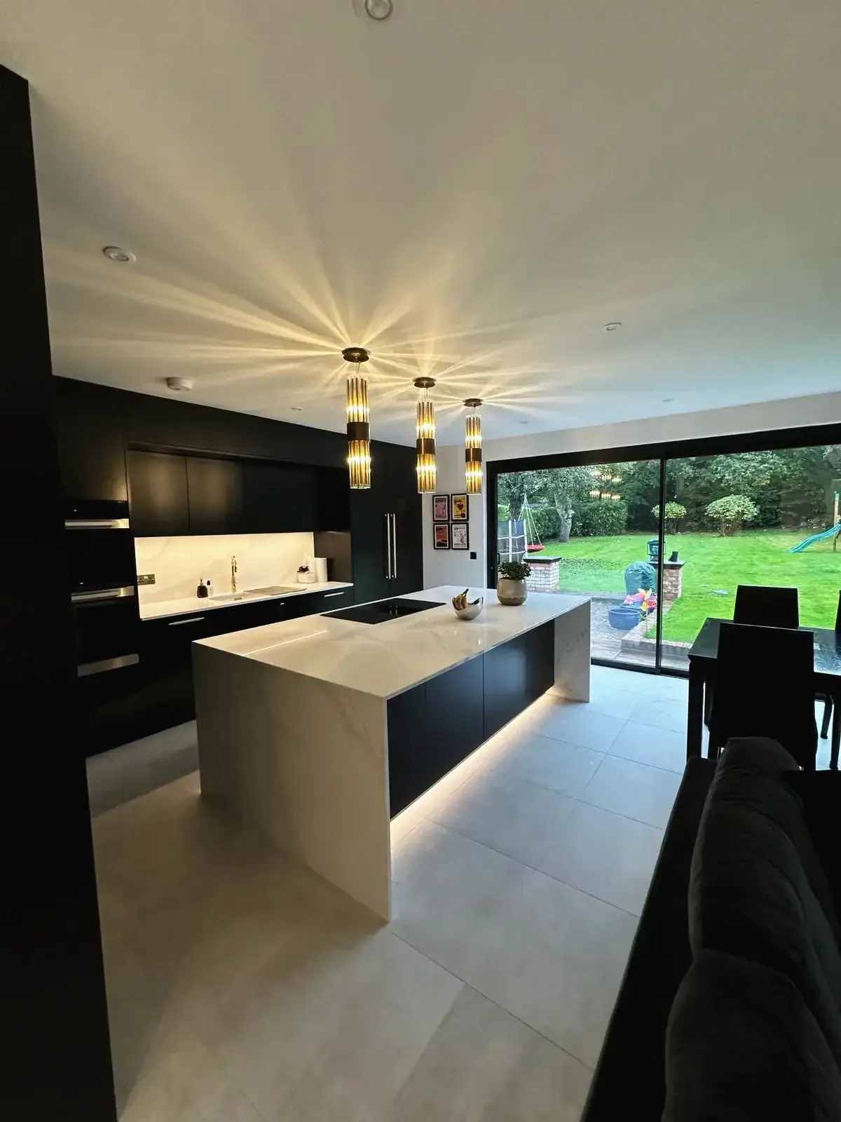 Modern kitchen island with pendant lighting and garden view