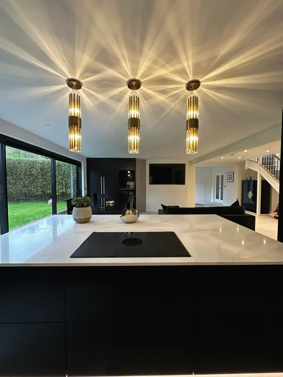 Modern kitchen island with pendant lights in open-plan living