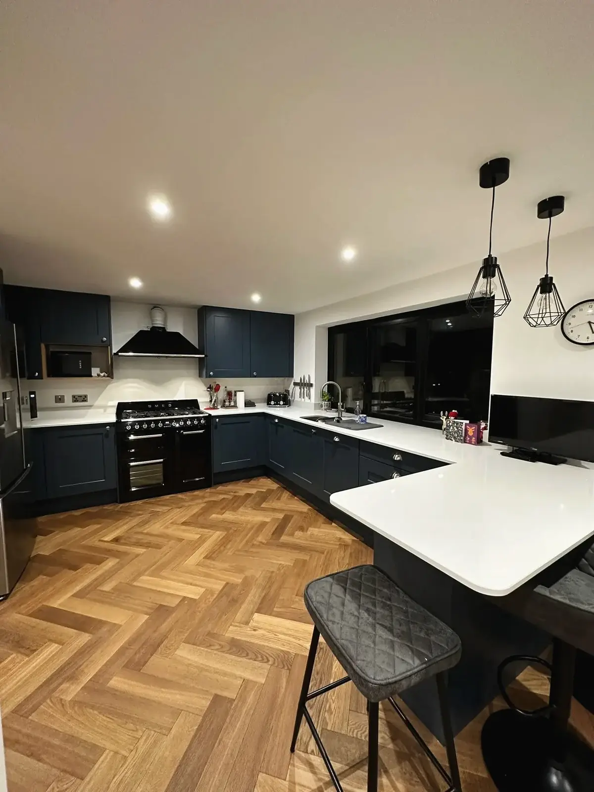Modern kitchen renovation with navy cabinets and breakfast bar