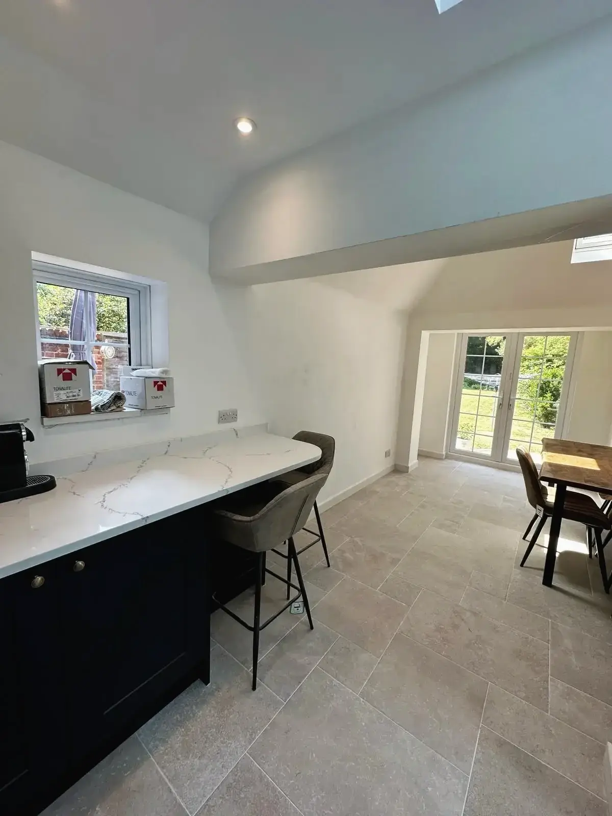 Modern kitchen renovation with tiled flooring and bar stools