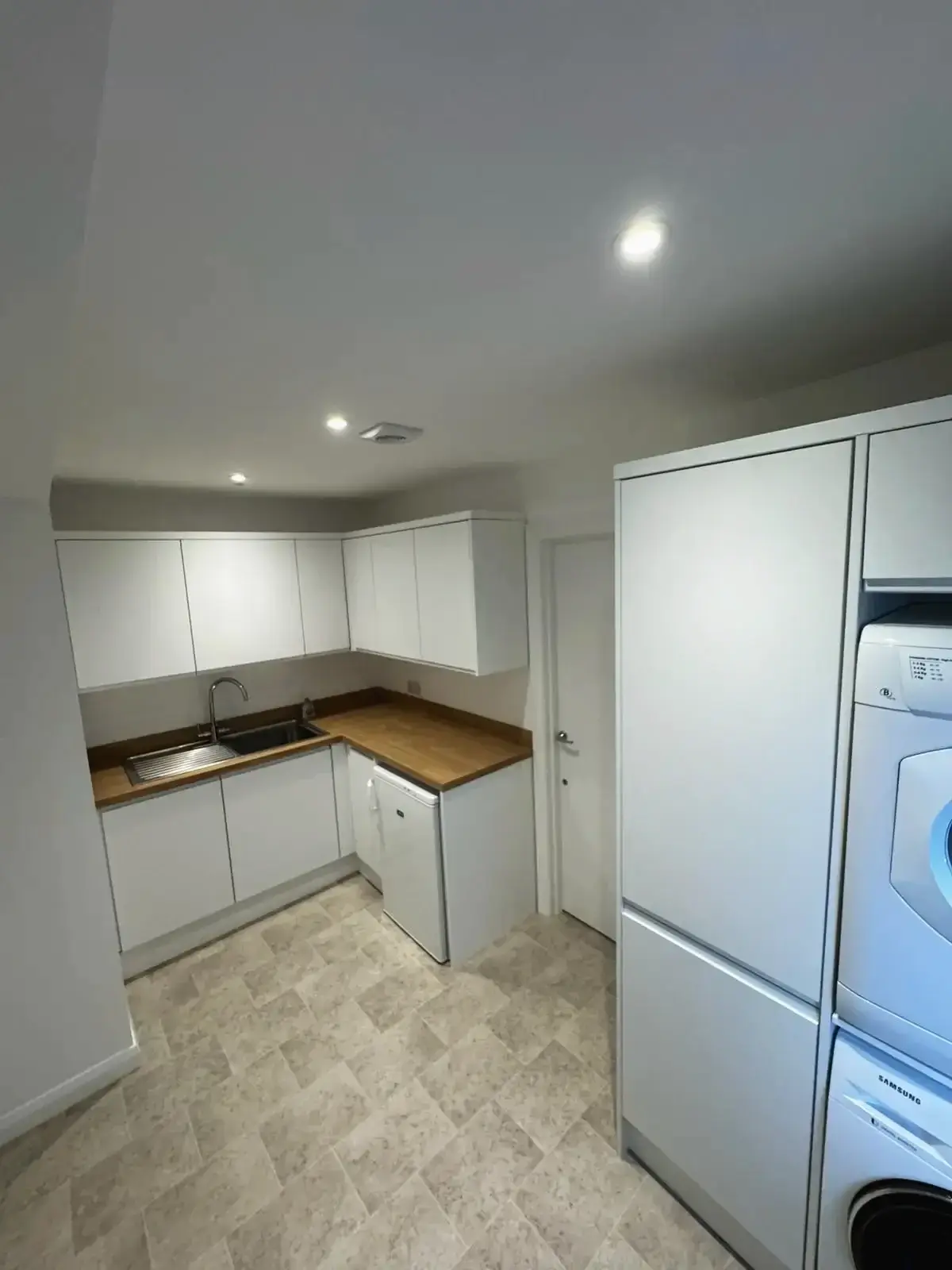 Modern kitchen renovation with white cabinets and wooden worktops