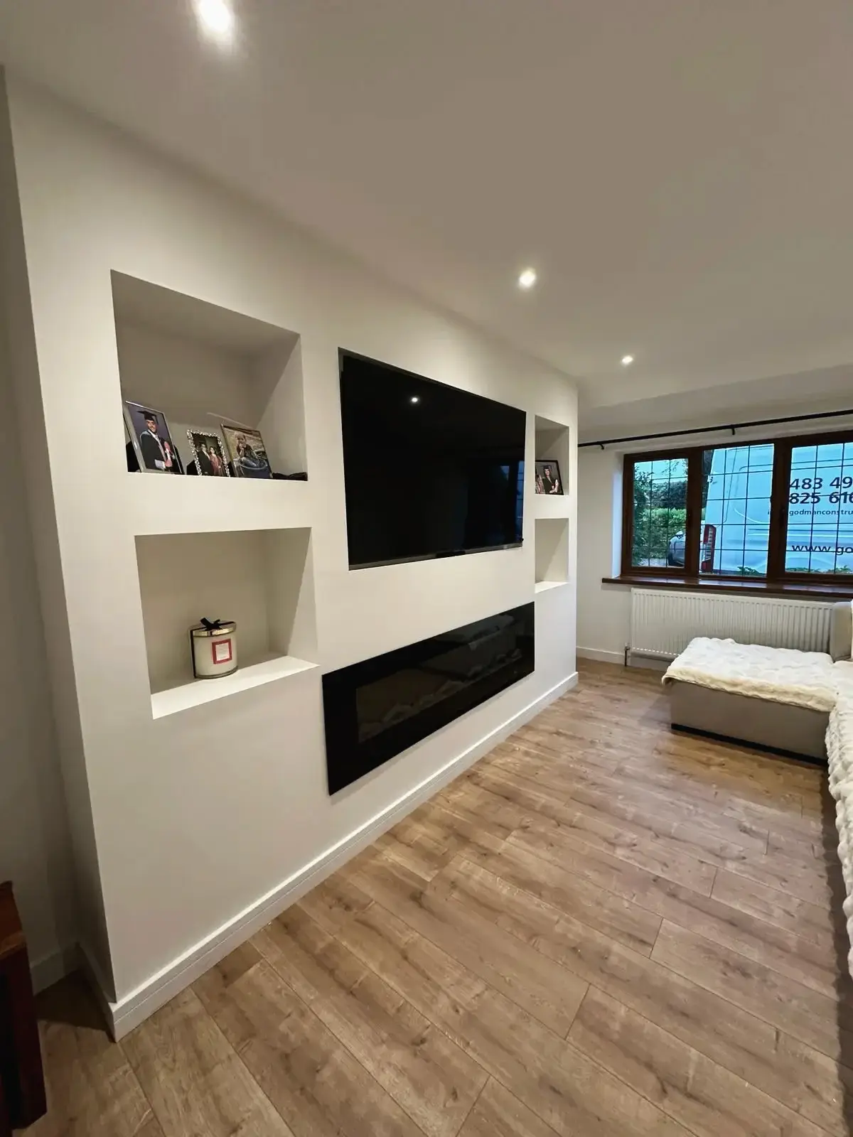 Modern living room with built-in TV wall and shelves