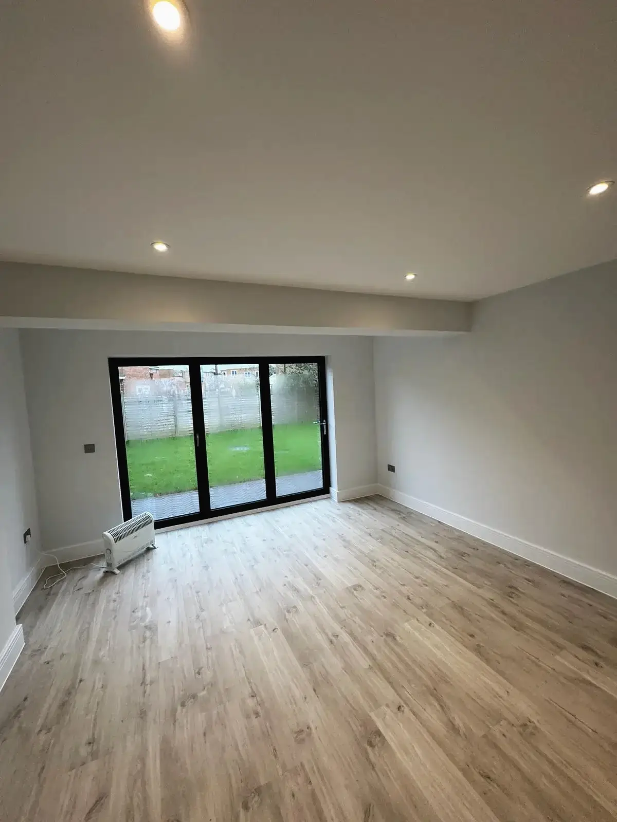 Modern living space featuring oak-effect flooring and garden access