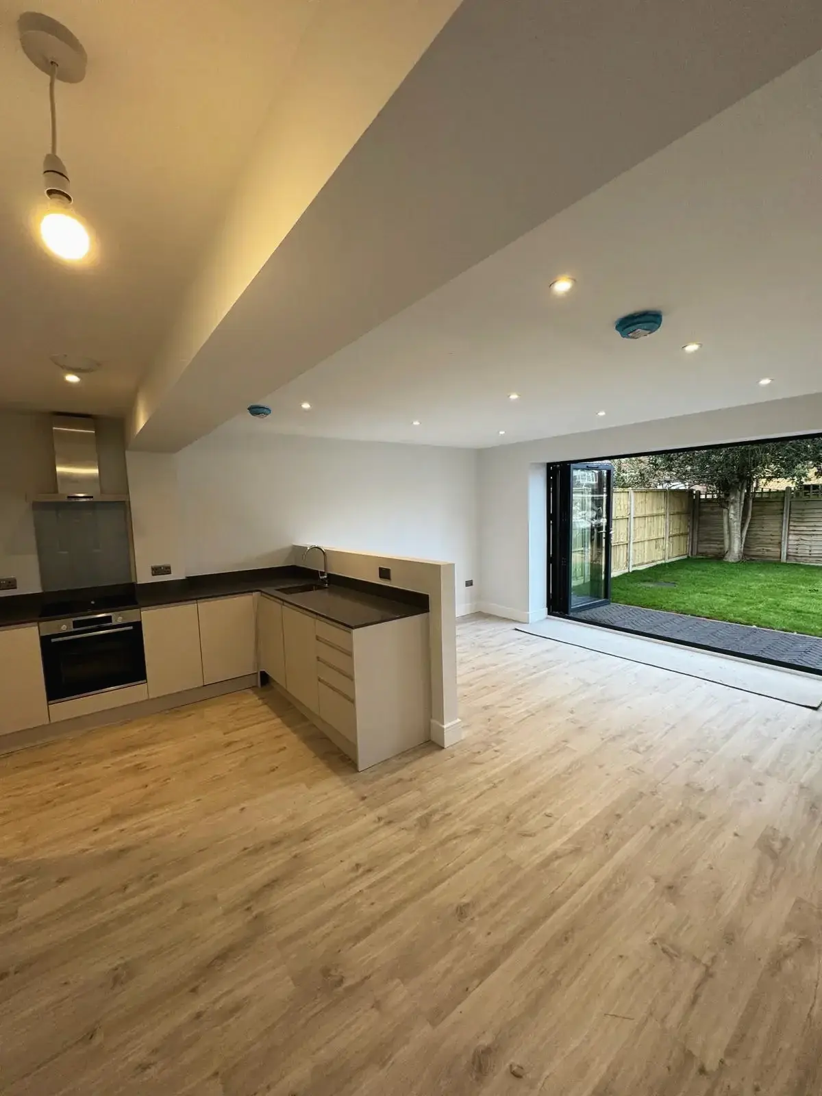 Modern open-plan kitchen with bi-fold doors leading to garden