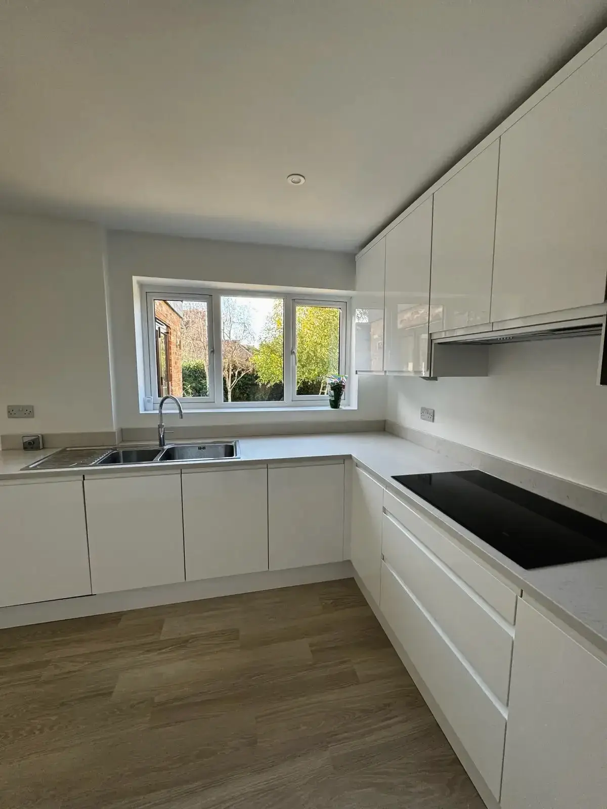Modern white kitchen with induction hob and double sink