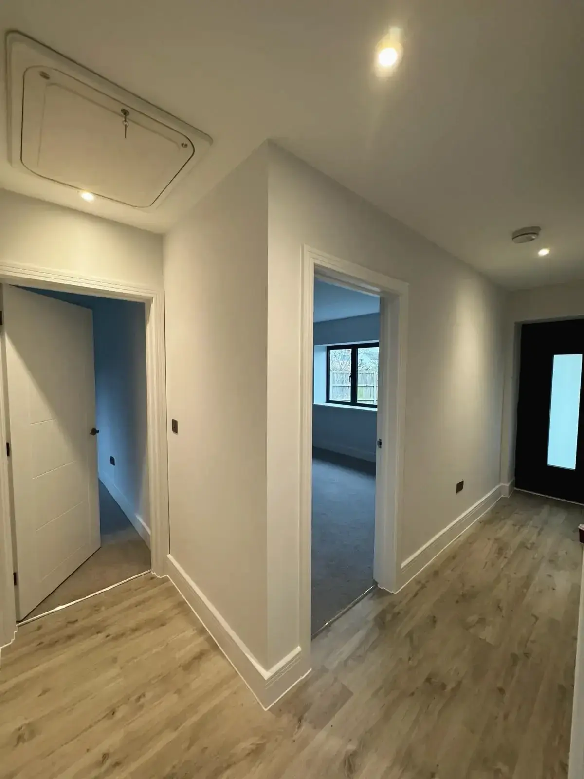 New hallway with modern flooring and bedroom access