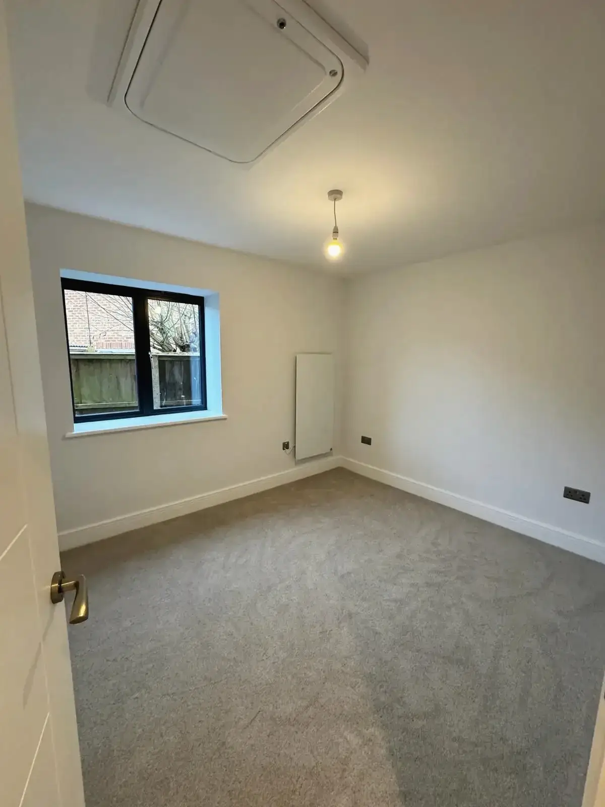 Simple modern bedroom interior after renovation with soft grey carpet