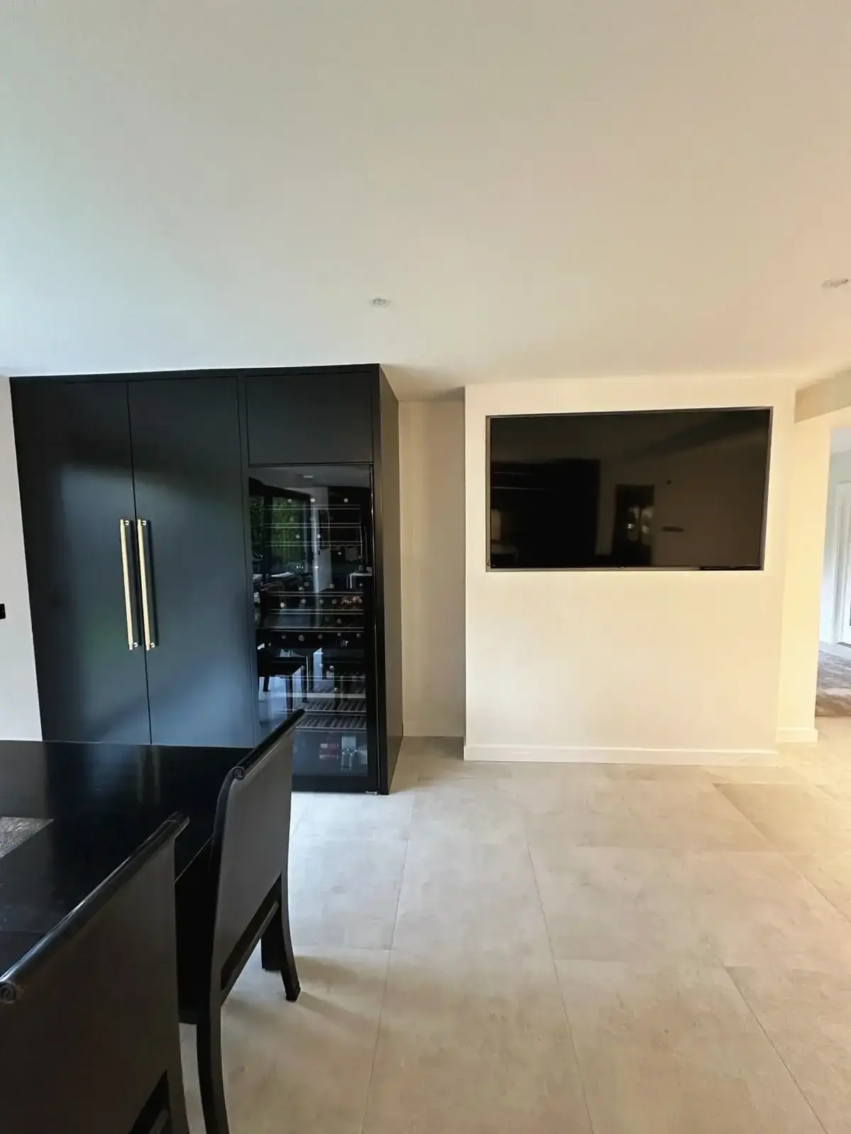 Sleek black storage units and dining area in open-plan space