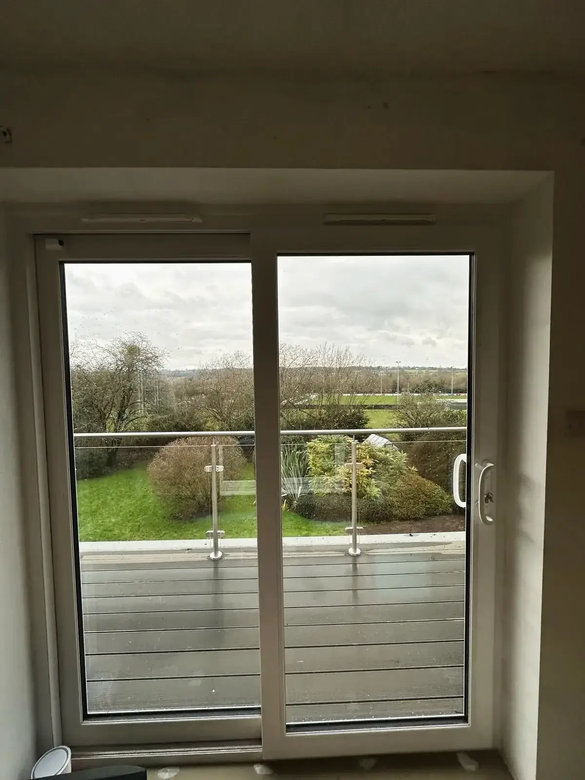Sliding glass door leading to balcony with glass balustrade