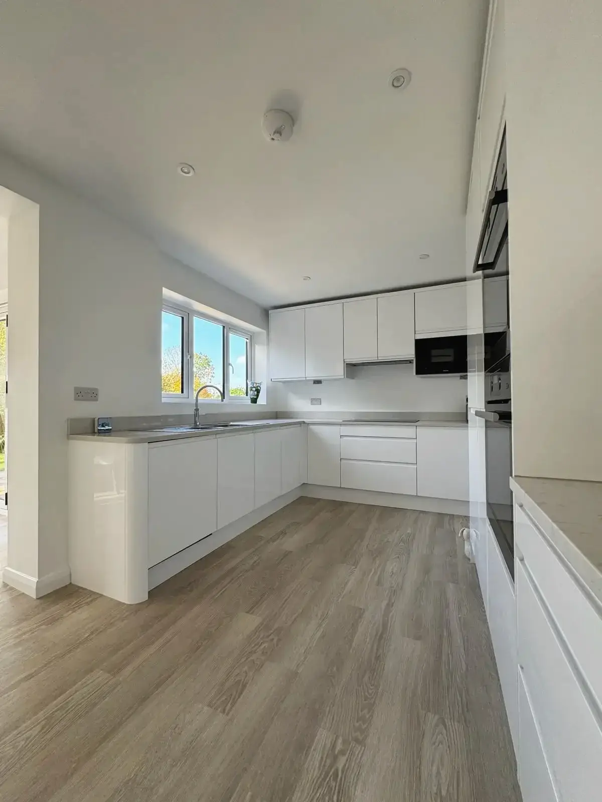 Spacious contemporary kitchen design with minimalist white units