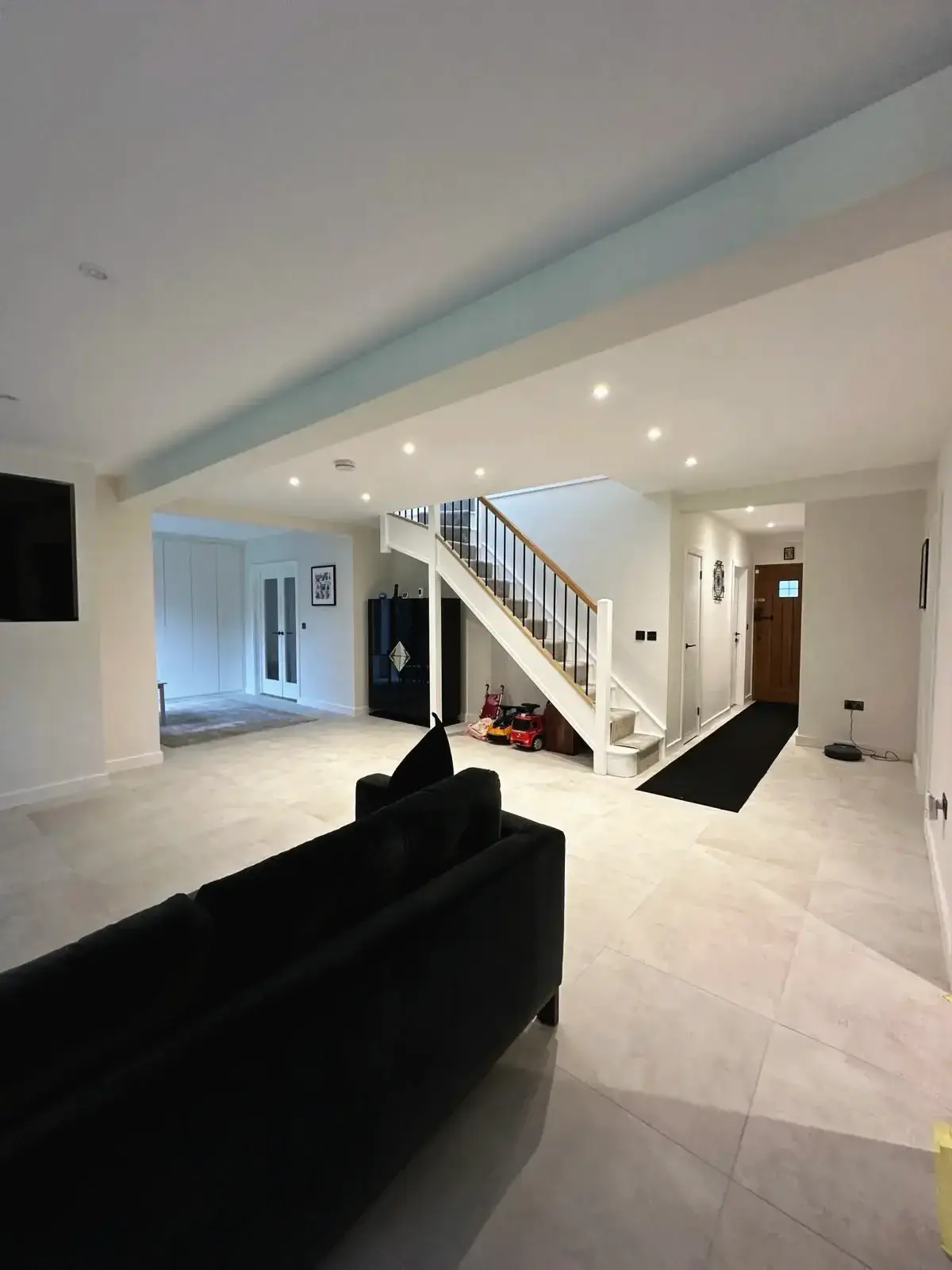 Spacious living area renovation with sleek staircase design
