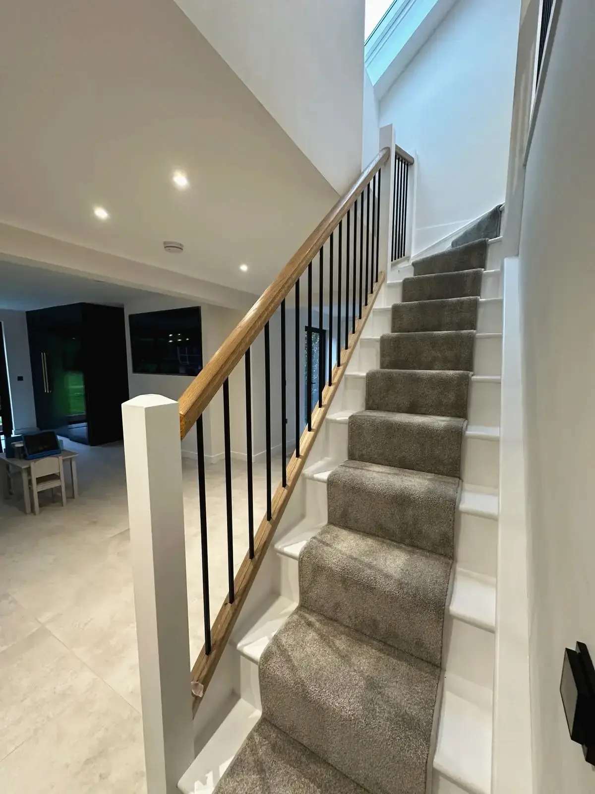 Modern staircase with wooden handrail in private home renovation