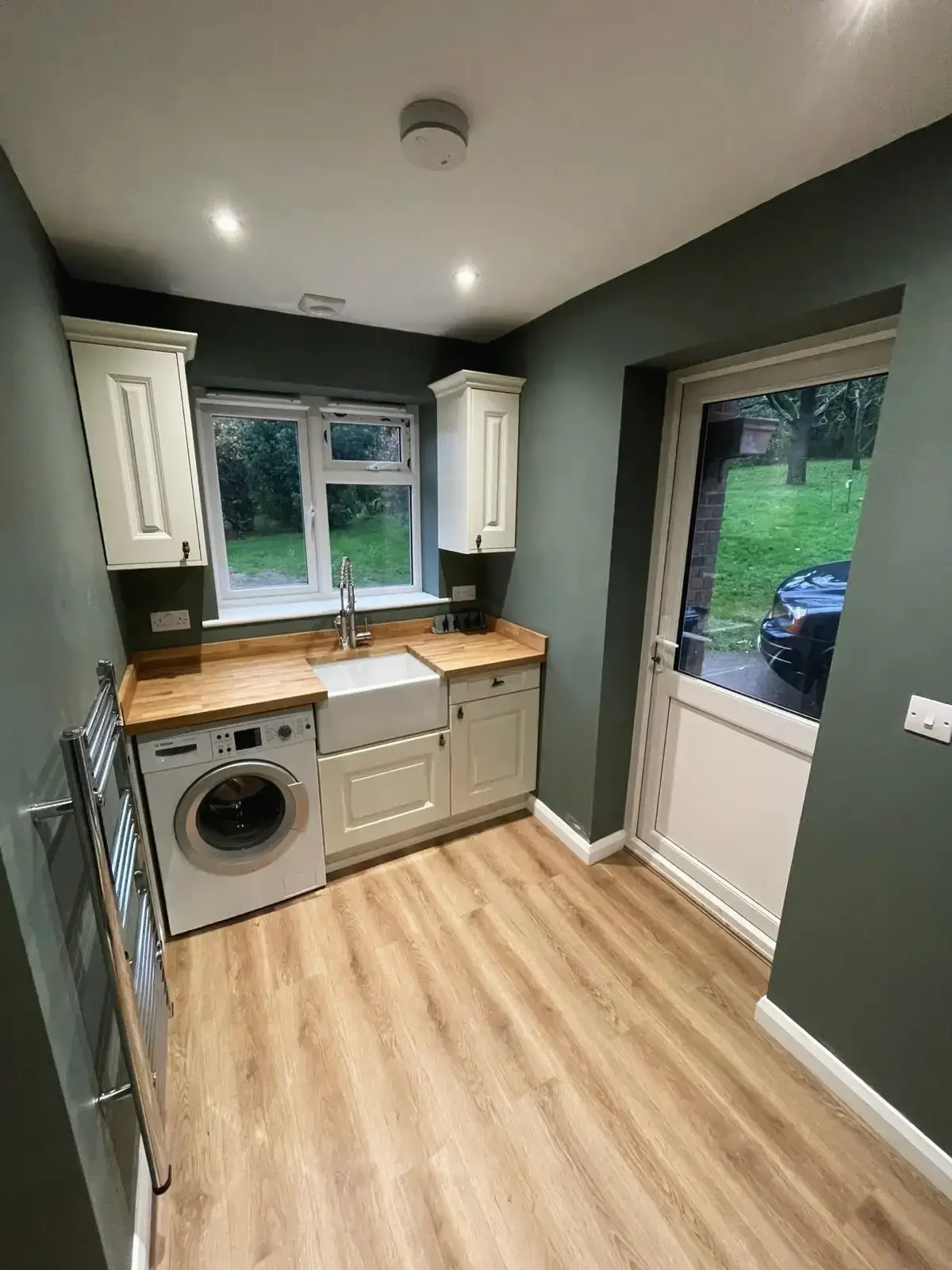 Utility space with integrated washer and white cabinets