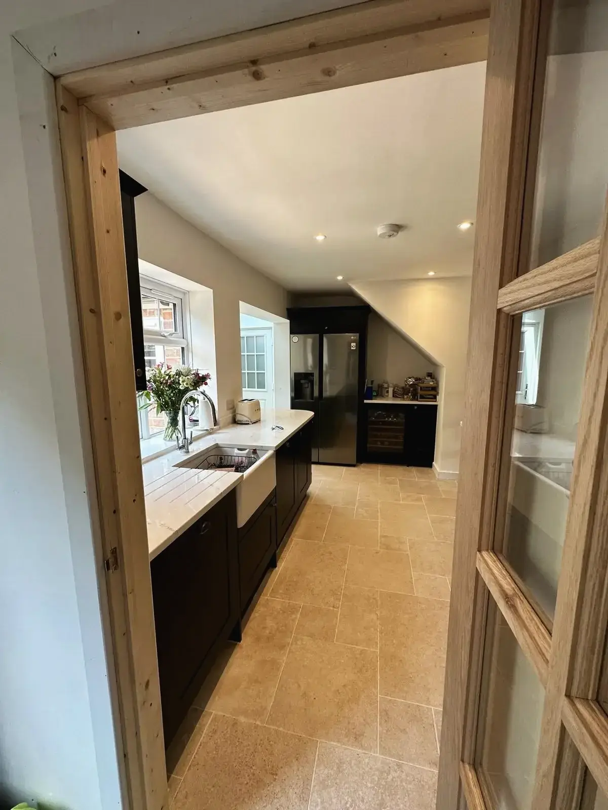 View of renovated kitchen through wooden doorway