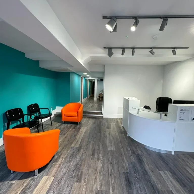 Office reception with track lighting, wooden flooring, and seating area | Loft Conversions in Chobham by Godman Construction