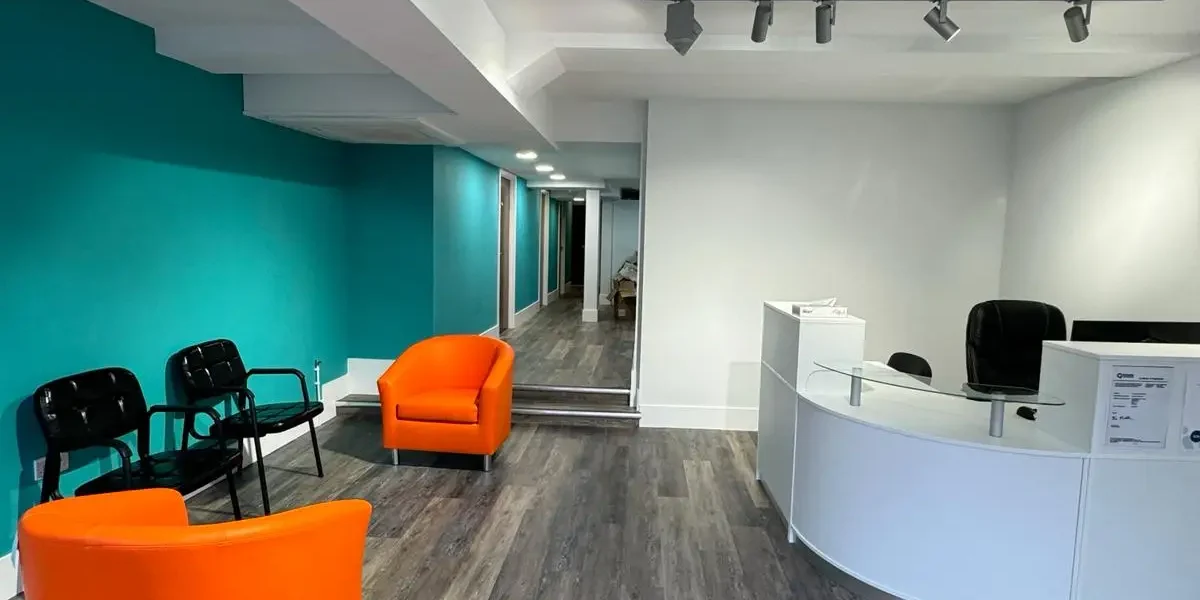 Office reception with track lighting, wooden flooring, and seating area | Loft Conversions in Chobham by Godman Construction